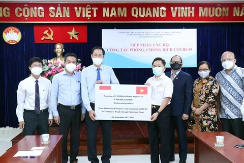 Ông Nguyễn Thành Trung, Phó Chủ tịch Ủy ban Mặt trận Tổ quốc Việt Nam Thành phố Hồ Chí Minh (thứ 3 từ trái sang) tiếp nhận tượng trưng số tiền và hàng hóa do doanh nghiệp và cộng đồng người Indonesia trao tặng. (Ảnh: Xuân Khu/TTXVN)