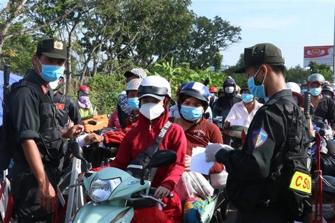 Lực lượng chức năng kiểm tra giấy tờ tại chốt kiểm soát dịch, khi hàng ngàn dân từ Thành phố Hồ Chí Minh và các tỉnh lân cận đổ về quê qua địa phận Long An, ngày 1/10/2021. (Ảnh: Bùi Giang/TTXVN)
