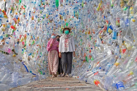 Người dân đi qua một đường hầm được tạo ra bằng các chai nhựa. (Nguồn: reuters.com)