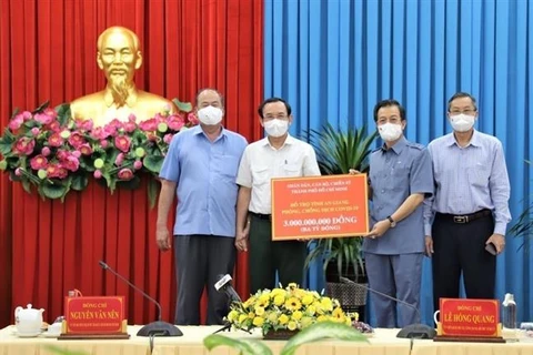 Bí thư Thành ủy Thành phố Hồ Chí Minh Nguyễn Văn Nên (thứ hai từ trái sang) trao tặng 3 tỷ đồng hỗ trợ An Giang phòng, chống dịch COVID-19. (Ảnh: Thanh Sang/TTXVN)