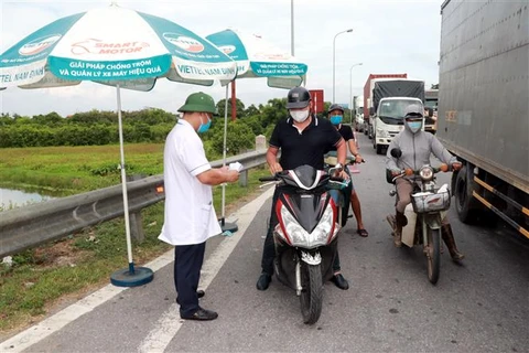 Kiểm tra giấy xét nghiệm tại một chốt kiểm soát dịch COVID-19 tại Nam Định, hồi tháng 7/2021. (Ảnh: Văn Đạt/TTXVN)