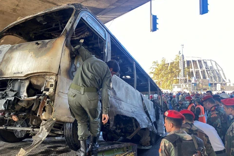 Lực lượng an ninh kiểm tra hiện trường vụ đánh bom nhằm vào xe buýt quân sự ở trung tâm Damascus (Syria), ngày 20/10/2021. (Nguồn: reuters.com)