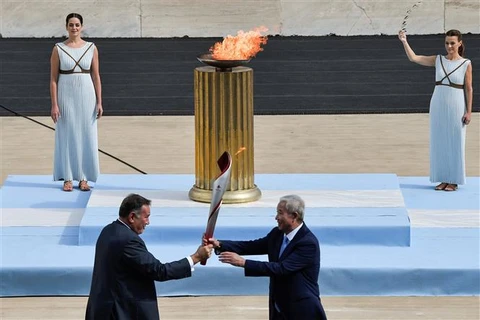 Giám đốc Ủy ban Olympic Hy Lạp Spyros Kapralos (trái) trao ngọn đuốc Olympic cho Phó Chủ tịch Ban tổ chức Olympic Bắc Kinh 2022 Yu Zaiqing tại sân vận động Panathenaic ở Athens, ngày 19/10/2021. (Ảnh: AFP/TTXVN)