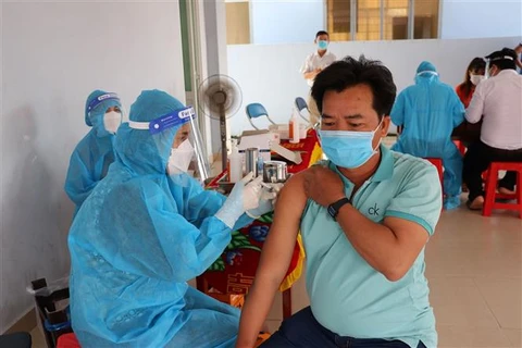 Công nhân, người lao động tại tỉnh Tiền Giang được tiêm vaccine phòng COVID-19 để sớm quay trở lại sản xuất. (Ảnh: Hữu Chí/TTXVN)