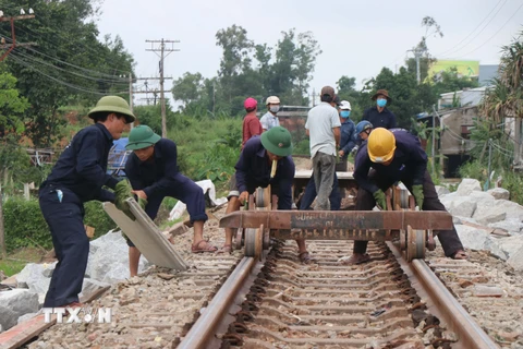 Công nhân Công ty Cổ phần Đường sắt Quảng Nam-Đà Nẵng nỗ lực khắc phục đoạn đường sắt bị hư hỏng. (Ảnh: Sỹ Thắng/TTXVN)