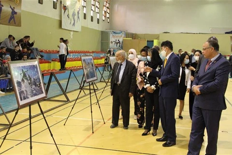 Đại sứ Nguyễn Thành Vinh cùng các khách mời tham quan triển lãm. (Ảnh: Tấn Đạt/TTXVN)