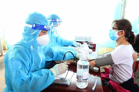 Khám sàng lọc cho người dân tại một điểm tiêm vaccine phòng COVID-19 tại thành phố Trà Vinh. (Ảnh: Thanh Hòa/TTXVN)