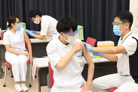Nhân viên y tế tiêm vaccine phòng COVID-19 cho người dân tại Tokyo (Nhật Bản). (Ảnh: AFP/TTXVN)