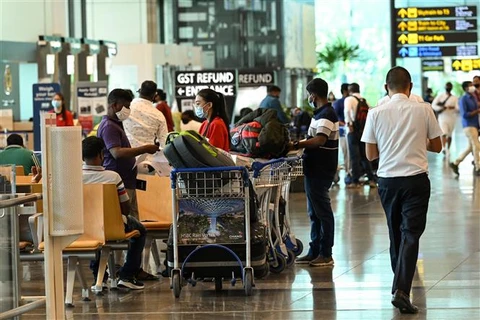Hành khách đeo khẩu trang phòng dịch COVID-19 tại sân bay quốc tế Changi (Singapore), ngày 15/3/2021. (Ảnh: AFP/TTXVN)