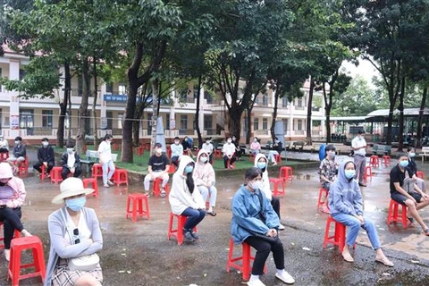 Người dân thành phố Đồng Xoài (Bình Phước) xếp hàng chờ tiêm vaccine, ngày 12/10/2021. (Ảnh: TTXVN)