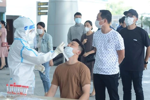 Nhân viên y tế lấy mẫu xét nghiệm cho người dân tại Đà Nẵng, hồi tháng 5/2021. (Ảnh: Văn Dũng/TTXVN)