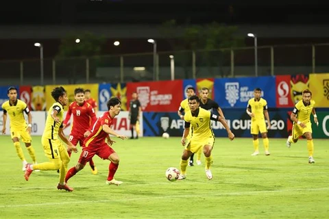 Tiền đạo Công Phượng (áo đỏ, phía trước) đi bóng trước các cầu thủ đội tuyển Malaysia. (Ảnh: TTXVN)