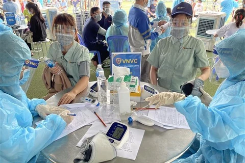 Tiêm vaccine phòng COVID-19 cho người lao động tại khu công nghiệp VSIP (Bình Dương), hồi tháng 8/2021. (Ảnh: Huyền Trang/TTXVN)