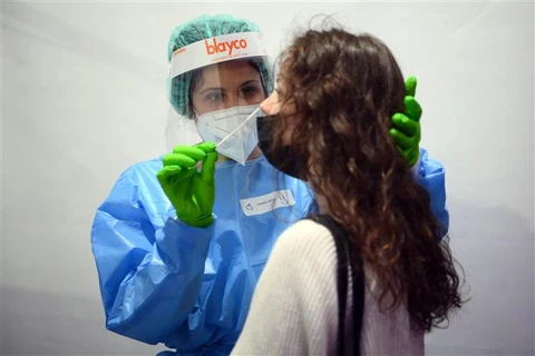 Nhân viên y tế lấy mẫu xét nghiệm COVID-19 cho người dân tại Barcelona (Tây Ban Nha). (Ảnh: AFP/TTXVN)