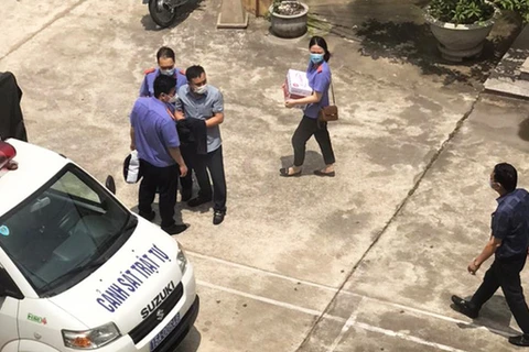 Ông Quang (góc phải) tại thời điểm Cơ quan điều tra Viện Kiểm sát nhân dân tối cao tống đạt quyết định khởi tố, bắt tạm giam nhóm cán bộ cấp dưới. (Nguồn: tuoitre.vn)