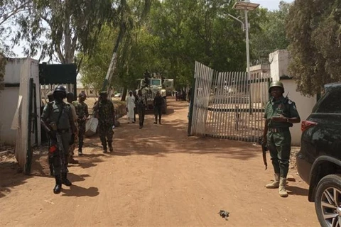 Lực lượng an ninh Nigeria gác tại cổng một trường đại học ở bang Kuduna nơi hàng chục sinh viên bị bắt cóc, ngày 12/3/2021. (Ảnh: AFP/TTXVN)