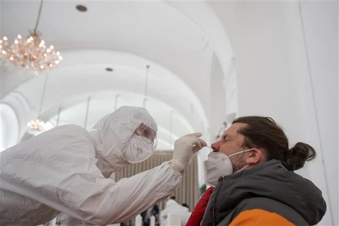 Nhân viên y tế lấy mẫu xét nghiệm COVID-19 tại Schoenbrunn (Áo). (Ảnh: AFP/TTXVN)