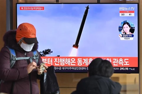 Người dân theo dõi bản tin tại Nhà ga Seoul (Hàn Quốc) về vụ phóng vật thể bay không xác định của Triều Tiên hướng ra Biển Nhật Bản, ngày 5/1/2022. (Ảnh: AFP/TTXVN)