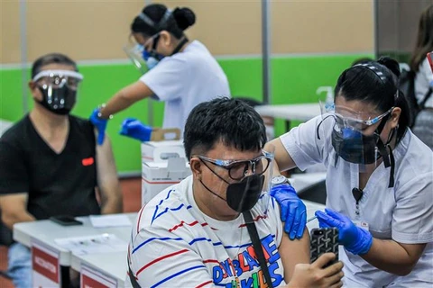 Nhân viên y tế tiêm vaccine phòng COVID-19 cho người dân tại Manila (Philippines). (Ảnh: THX/TTXVN)