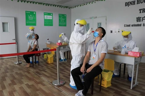 Lấy mẫu xét nghiệm COVID-19 cho người lao động của Công ty TNHH GoerTek Vina tại khu công nghiệp Quế Võ (Bắc Ninh), hồi tháng 8/2021. (Ảnh: Thanh Thương/TTXVN)