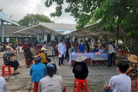 Người dân chờ tiêm vaccine phòng COVID-19 tại thị trấn Sông Đốc, huyện Trần Văn Thời (Cà Mau). (Ảnh: Kim Há/TTXVN)