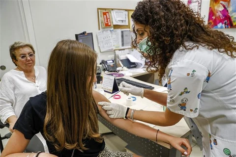 Nhân viên y tế tiêm vaccine ngừa COVID-19 cho người dân tại thành phố Holon (Israel). (Ảnh: AFP/TTXVN)