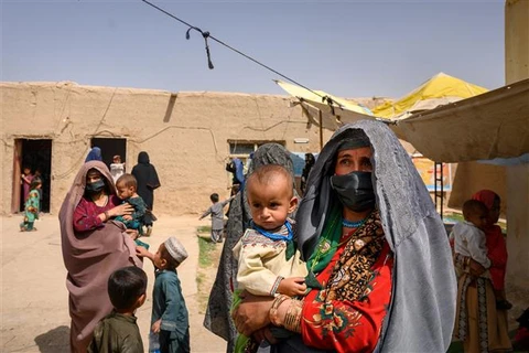 Phụ nữ và trẻ em sơ tán tránh xung đột tại tỉnh Helmand (Afghanistan), ngày 28/3/2021. (Ảnh: AFP/TTXVN)