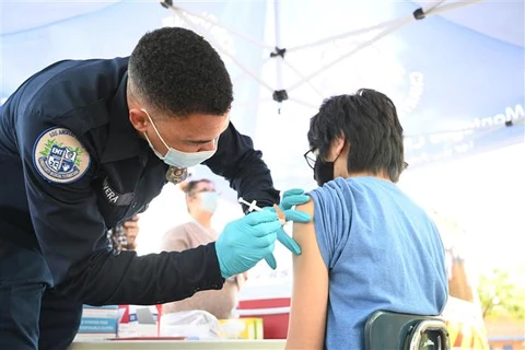Nhân viên y tế tiêm vaccine ngừa COVID-19 cho người dân tại Los Angeles (Mỹ). (Ảnh: AFP/TTXVN)
