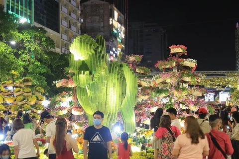 Người dân tham quan, đón giao thừa tại khu vực đường hoa Nguyễn Huệ, Quận 1 (Thành phố Hồ Chí Minh). (Ảnh: Quang Châu/TTXVN)