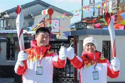 Hai vận động viên Ding Hui (trái) và Dong Qingping tham gia lễ rước đuốc Olympic mùa Đông Bắc Kinh 2022 tại Hà Bắc (Trung Quốc), ngày 3/2/2022. (Ảnh: THX/TTXVN)