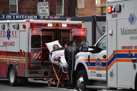 Nhân viên y tế chuyển bệnh nhân COVID-19 tới trung tâm y tế tại New York (Mỹ). (Ảnh: AFP/TTXVN)