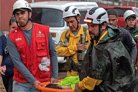 Lực lượng cứu hộ chuyển nạn nhân tại hiện trường vụ sạt lở đất do mưa lớn ở thành phố cổ Petropolis, Đông Nam Brazil, ngày 18/2/2022. (Ảnh: AFP/TTXVN)