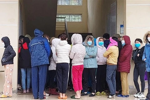 Công nhân chen nhau làm thủ tục xét nghiệm nhanh tại trạm y tế phường Bình Minh, thị xã Nghi Sơn (Thanh Hóa). (Ảnh: Trịnh Duy Hưng/TTXVN)