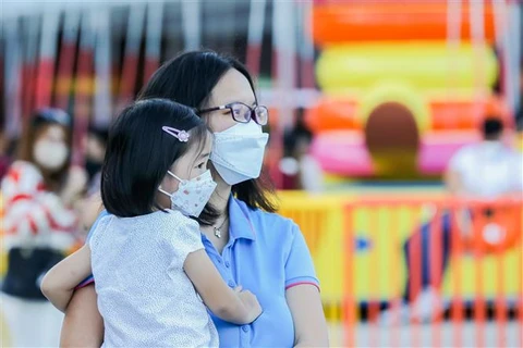 Một em nhỏ được mẹ cho đi chơi ở trung tâm giải trí tại Pasay (Philippines) ngày 24/2/2022. (Ảnh: THX/TTXVN)