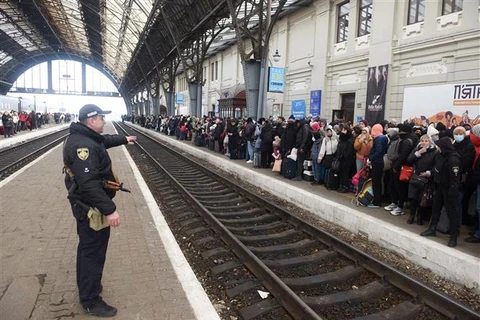 Người dân chờ tàu tới Ba Lan tại nhà ga thành phố Lviv (Ukraine) ngày 26/2/2022. (Ảnh: AFP/TTXVN)
