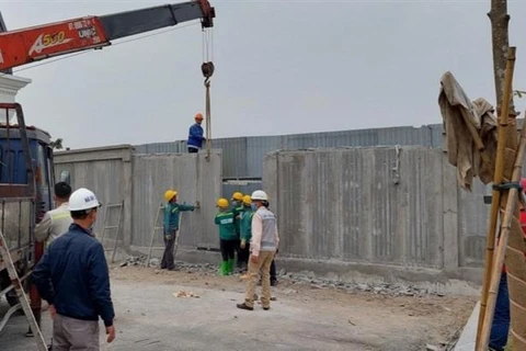 Ngày 2/3, Công ty cổ phần Đầu tư An Lạc đã bắt đầu cho công nhân phá dỡ bức tường bêtông đang chặn lối đi tại xã Vân Canh. (Ảnh: TTXVN)