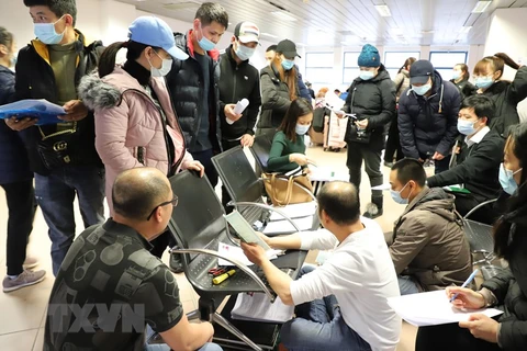 Cán bộ Đại sứ quán Việt Nam kiểm tra, cấp thẻ thông hành cho kiều bào ở sân bay thủ đô Bucharest (Romania). (Ảnh: Mạnh Hùng/TTXVN)