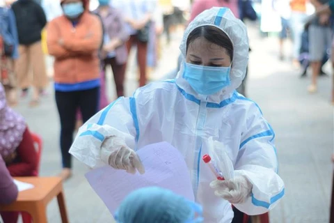 Nhân viên y tế hướng dẫn người dân thực hiện xét nghiệm COVID-19 tại quận Sơn Trà (Đà Nẵng). (Ảnh: Văn Dũng/TTXVN)