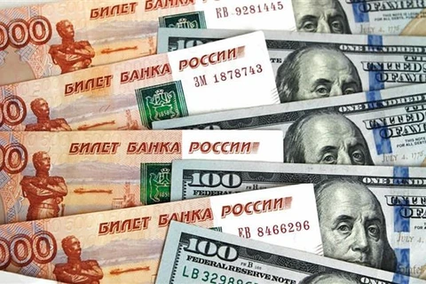 Đồng ruble của Nga (trái) và đồng đôla Mỹ. (Ảnh: Sputnik/TTXVN)