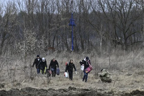 Người dân sơ tán khỏi thành phố Irpin, phía Tây Bắc Kiev (Ukraine) ngày 7/3/2022. (Ảnh: AFP/TTXVN)
