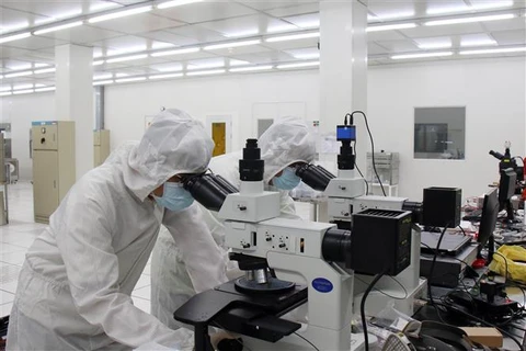 Các chuyên gia nghiên cứu công nghệ tại Phòng sạch Trung tâm Nghiên cứu triển khai Khu Công nghệ cao Thành phố Hồ Chí Minh. (Ảnh: Tiến Lực/TTXVN)