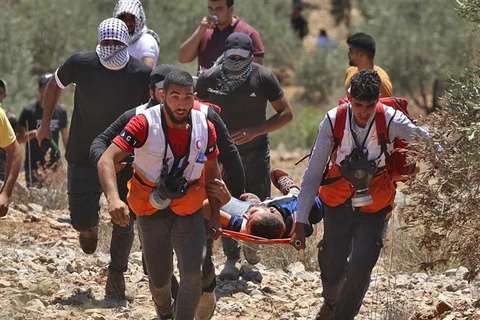 Chuyển người biểu tình Palestine bị thương trong xung đột với binh sỹ Israel tại thị trấn Beita, gần Nablus, khu Bờ Tây ngày 9/7/2021. (Ảnh: AFP/TTXVN)