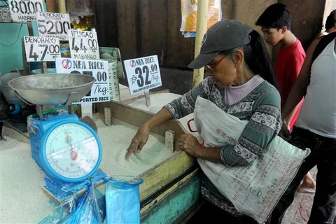 Người dân mua gạo tại một khu chợ ở Manila (Philippines). (Ảnh: AFP/TTXVN)