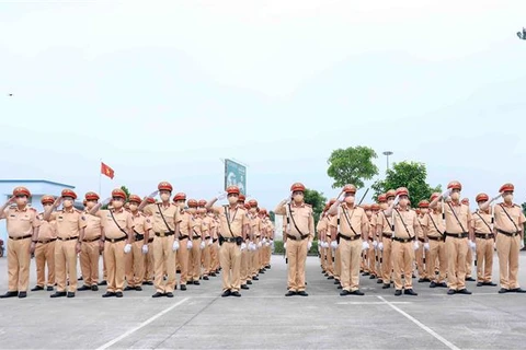 Cán bộ, chiến sỹ Cảnh sát Giao thông thực hiện nghi thức chào cờ tại buổi lễ. (Ảnh: Phạm Kiên/TTXVN)