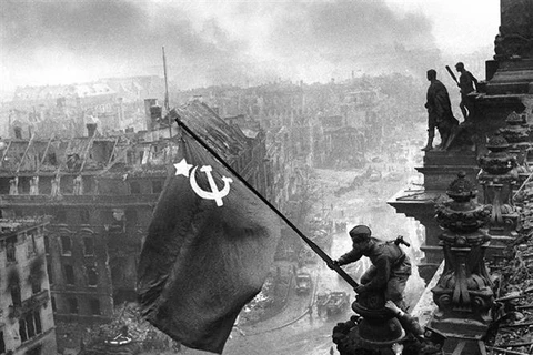 Chiến sỹ Hồng quân thuộc Phương diện quân Byelorussia 1 cắm lá cờ chiến thắng lên nóc Nhà Quốc hội Đức, chiều 30/4/1945. (Ảnh: Tư liệu quốc tế/TTXVN phát)