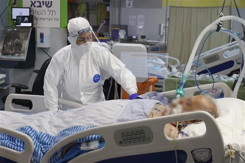 Nhân viên y tế điều trị cho bệnh nhân COVID-19 tại trung tâm y tế ở Ramat Gan (Israel). (Ảnh: AFP/TTXVN)