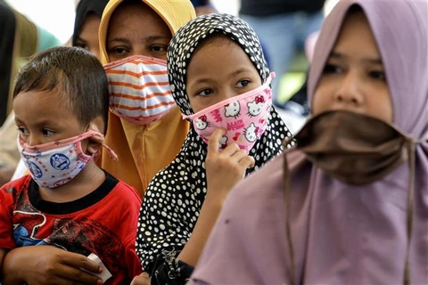 Trẻ em đeo khẩu trang phòng lây nhiễm COVID-19 tại Blang Bintang, Aceh (Indonesia). (Ảnh: AFP/TTXVN)