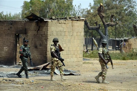 Binh sỹ và cảnh sát tuần tra tại làng Dalori, bang Borno (Nigeria), sau một cuộc tấn công của các tay súng Boko Haram hồi năm 2016. (Ảnh: AFP/TTXVN)