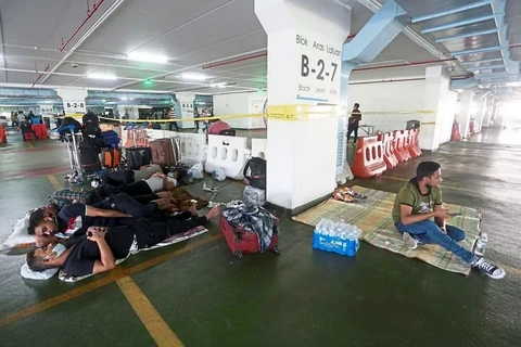 Người nhập cư ngủ ở một khu đỗ xe tại sân bay quốc tế Kuala Lumpur. (Nguồn: straitstimes.com)