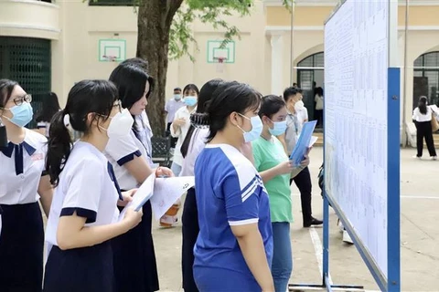 Thí sinh tìm phòng thi và số báo danh tại điểm thi Trường THPT Lê Quý Đôn (Quận 3). (Ảnh: Hồng Giang/TTXVN)
